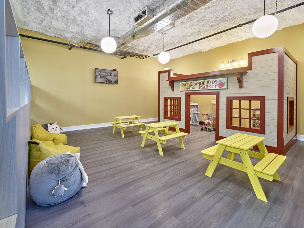 a play area with picnic tables and chairs and a play house