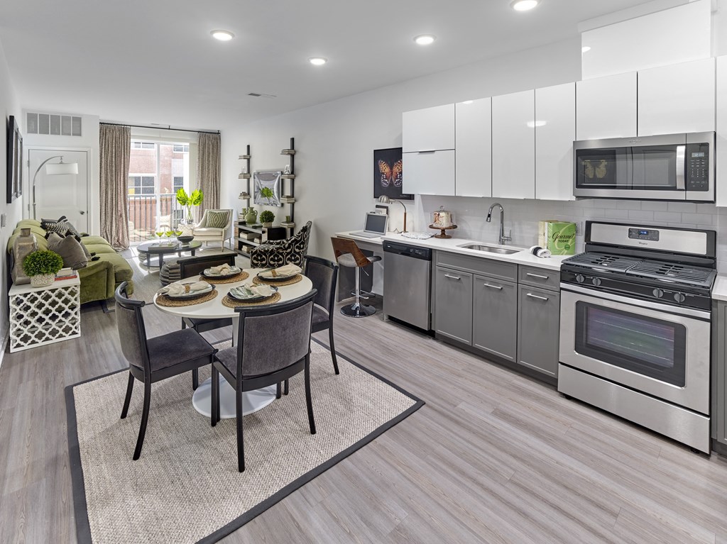 a kitchen and living room with stainless steel appliances and a table