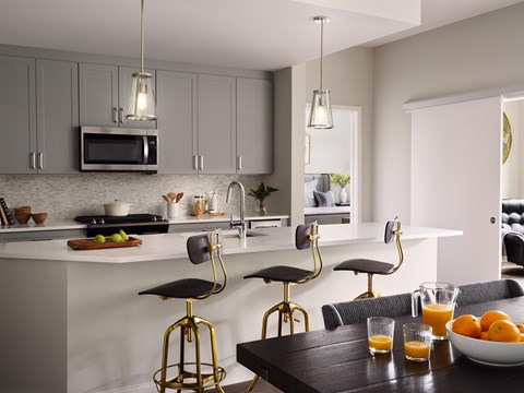 A kitchen with a table and chairs and a bowl of fruit on it.