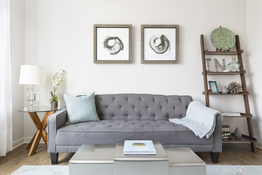 a living room with a gray couch and two pictures on the wall