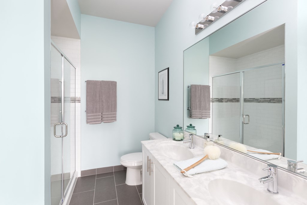 a bathroom with two sinks and a shower and a toilet