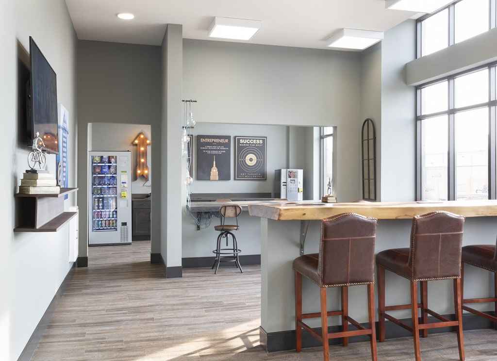a kitchen with a bar and chairs in front of a window