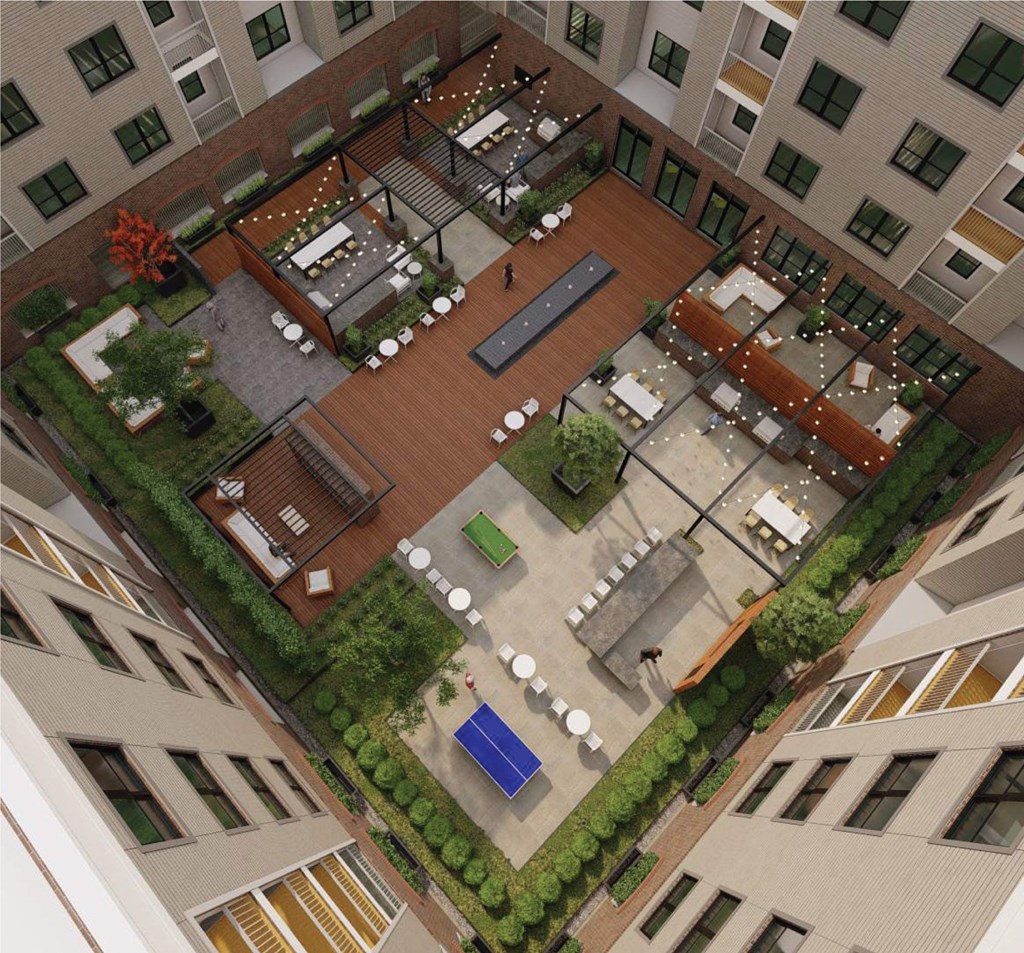 A courtyard surrounded by buildings with a blue table in the middle.