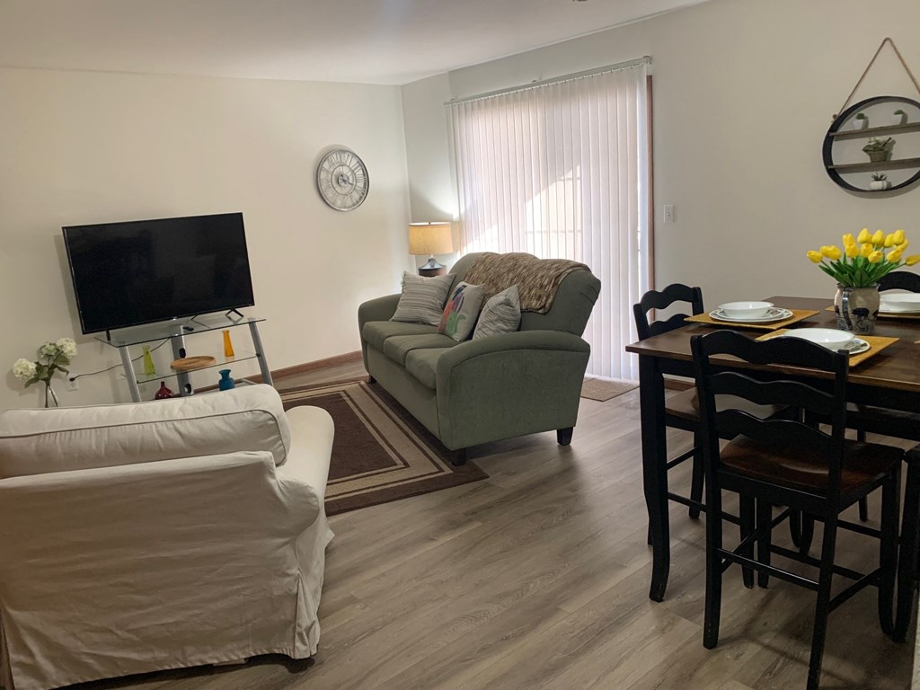 a living room and dining room with a couch and a tv