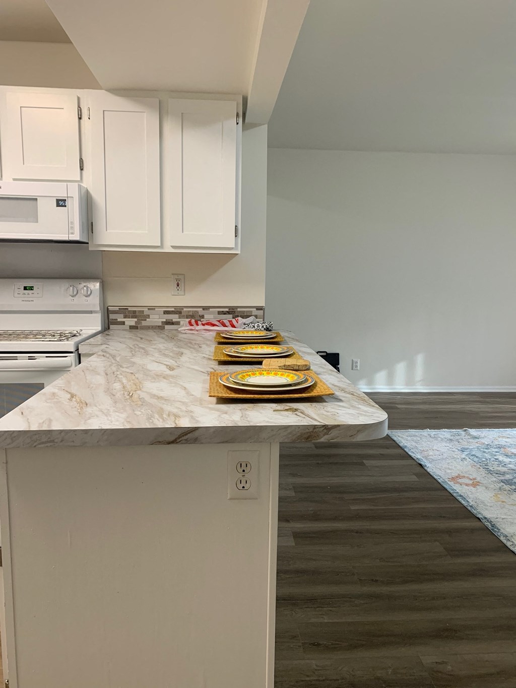a kitchen with white cabinets and a marble counter top