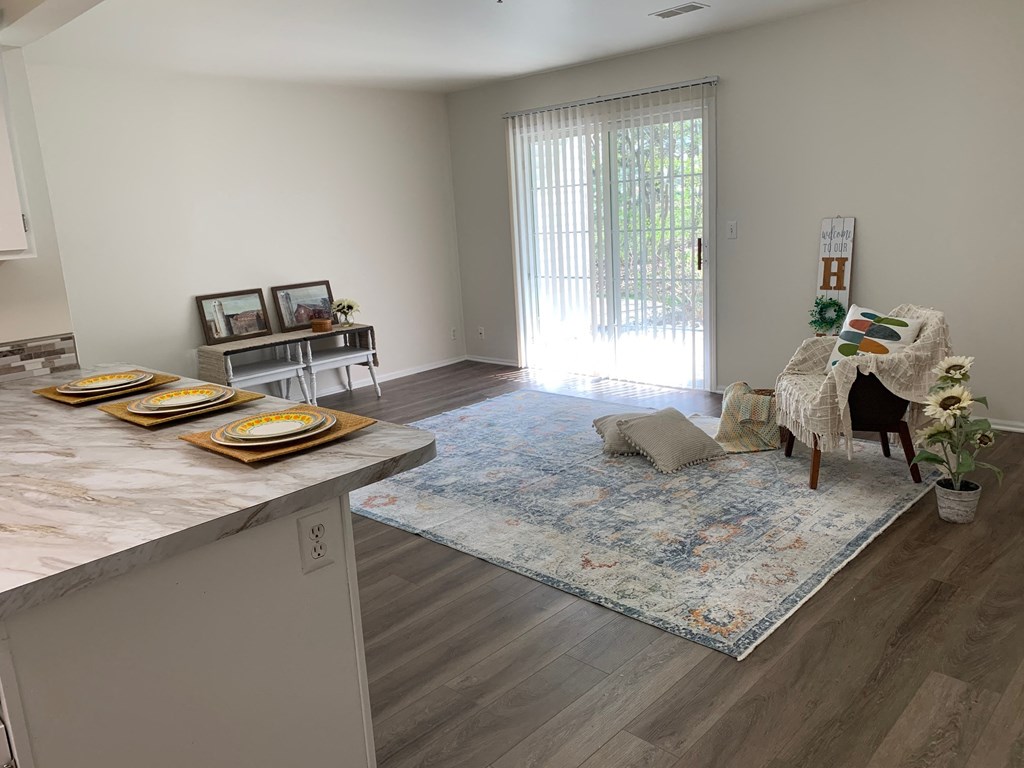 a living room and dining room with a sliding glass door