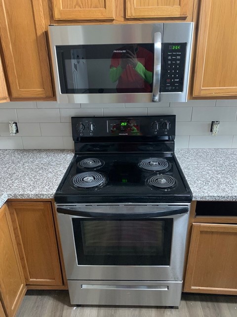 A stainless steel oven with a glass door is in a kitchen.