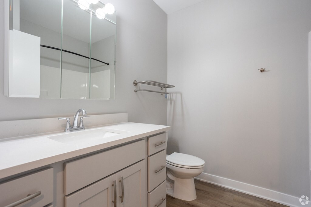 A white sink with a silver faucet and a white toilet in a bathroom.