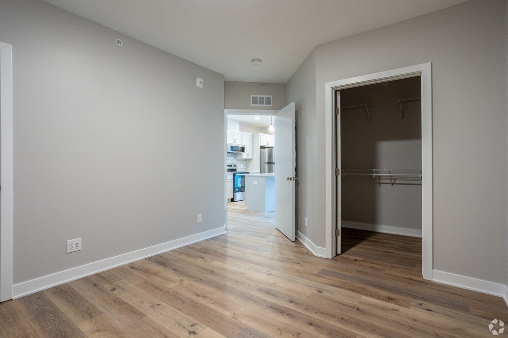 A room with a wooden floor and a doorway leading to another room.