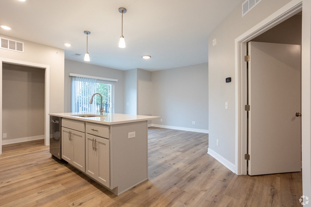 A kitchen with a window and wooden floors.