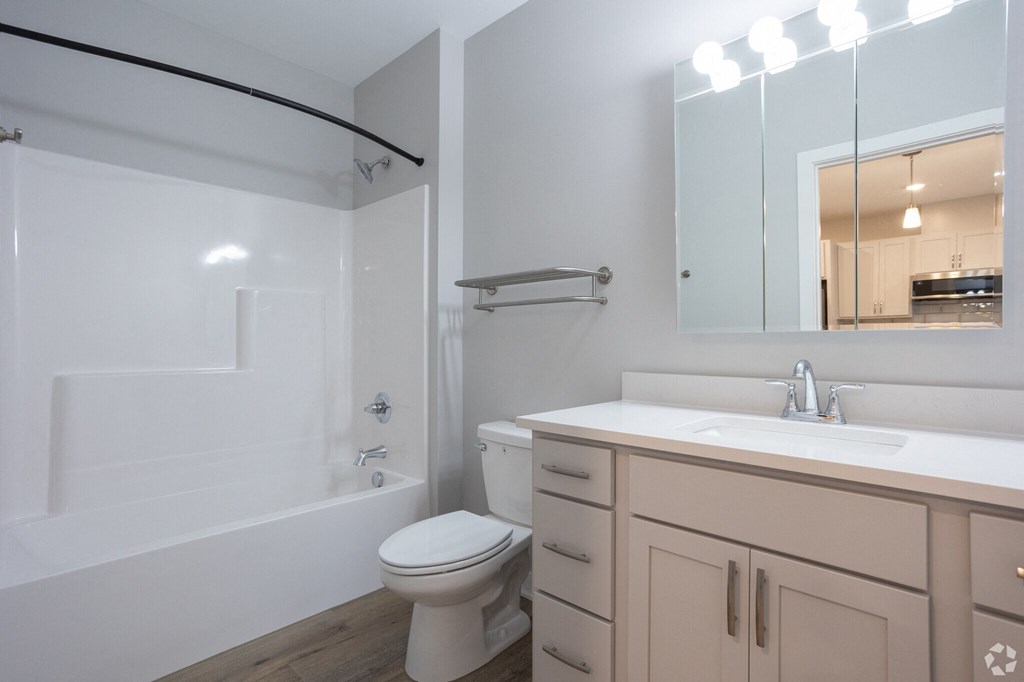 A white toilet sits in a bathroom next to a sink.