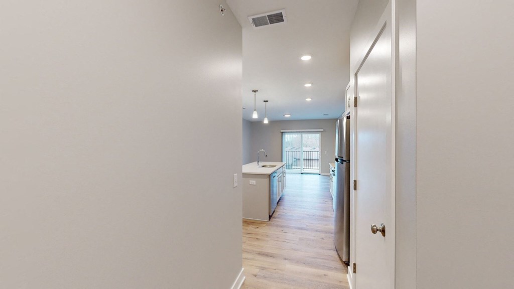 A kitchen with white walls and wooden floors.