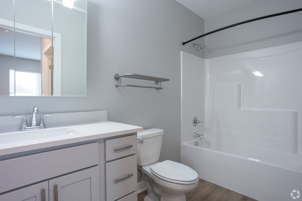 A white toilet sits next to a sink in a modern bathroom.