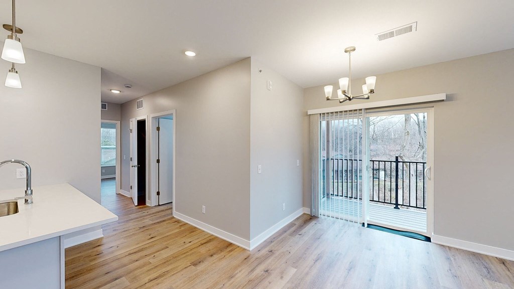 A kitchen with a sink and a dining table.