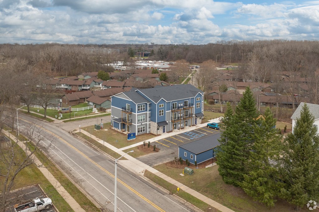 A blue building is in the middle of a road.