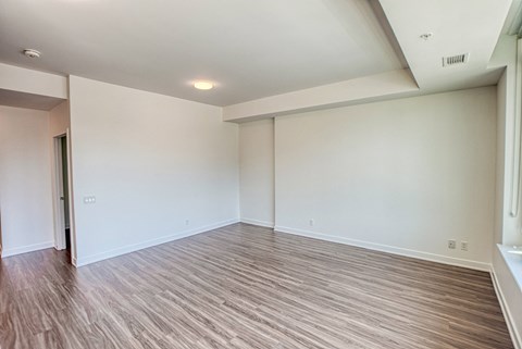 an empty living room with wood flooring and white walls