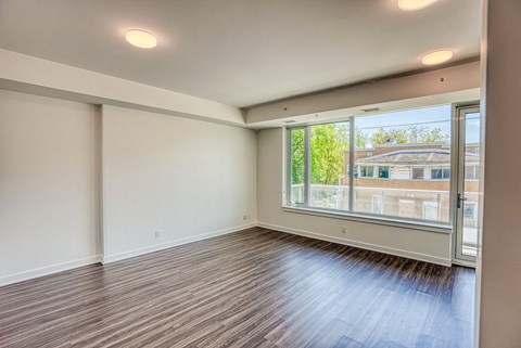 the living room of an empty apartment with a large window