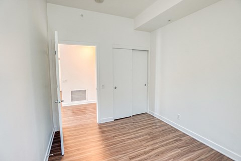 an empty room with wood flooring and white walls