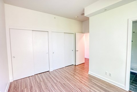 an empty living room with white walls and wood flooring