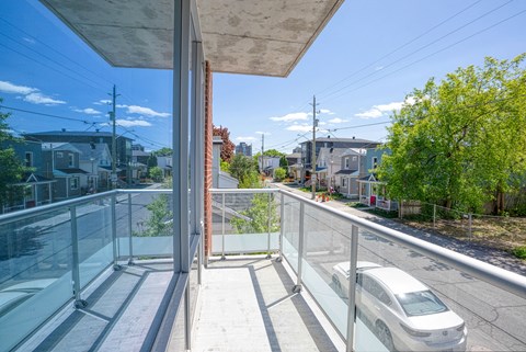 a balcony with glass railing and a white car on it