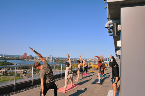 a group of people doing yoga on the roof of a building