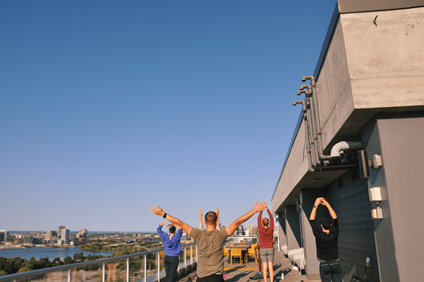 a group of people standing on the top of a building with their hands up