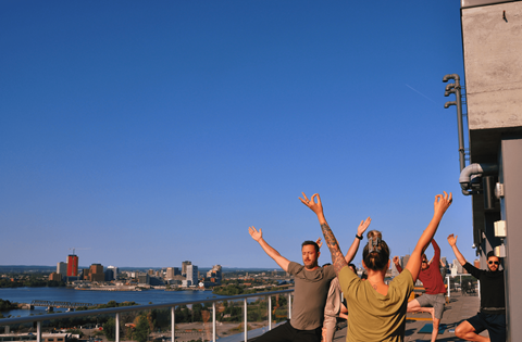 a group of people on a balcony with their hands up in the air