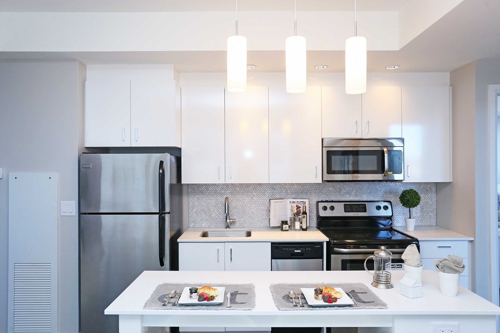 a white kitchen with stainless steel appliances and white cabinets