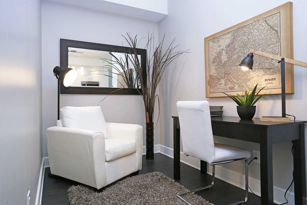 a living room with two white chairs and a desk with a mirror