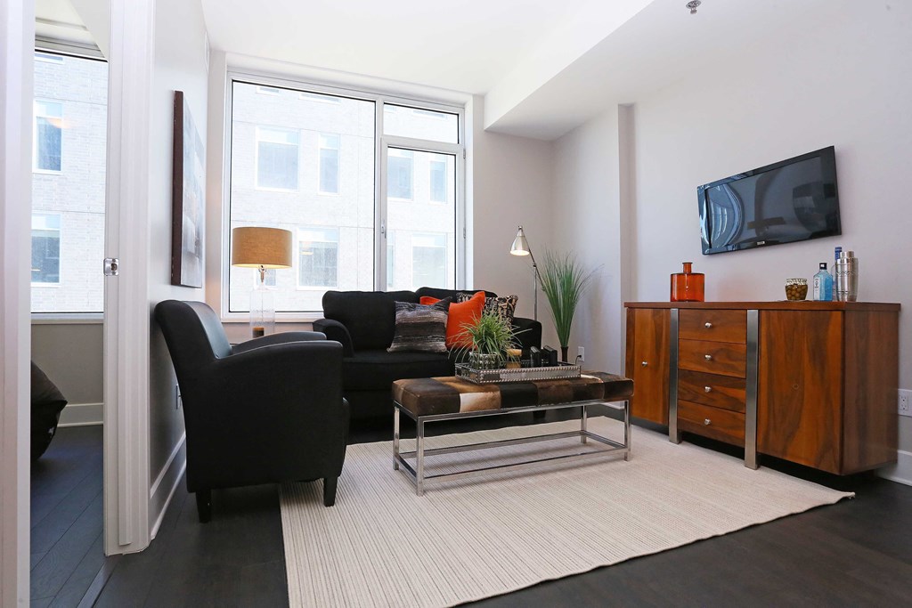a living room with a black couch and a television