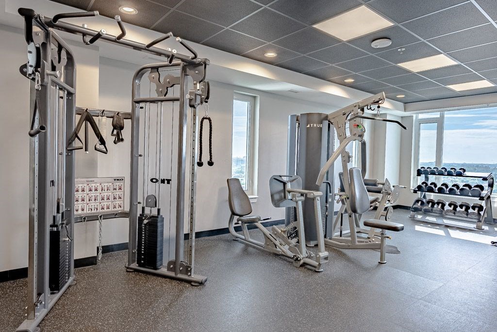 a gym with weights and other equipment in a room with windows