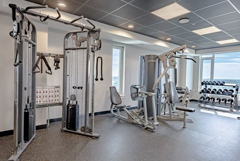 a gym with weights and other equipment in a room with a window