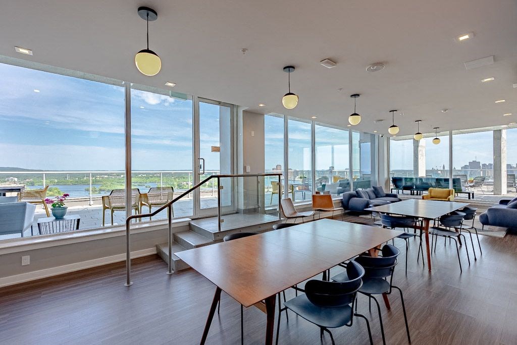 a communal area with tables and chairs and large windows