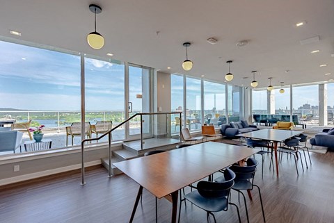 a communal area with tables and chairs and large windows