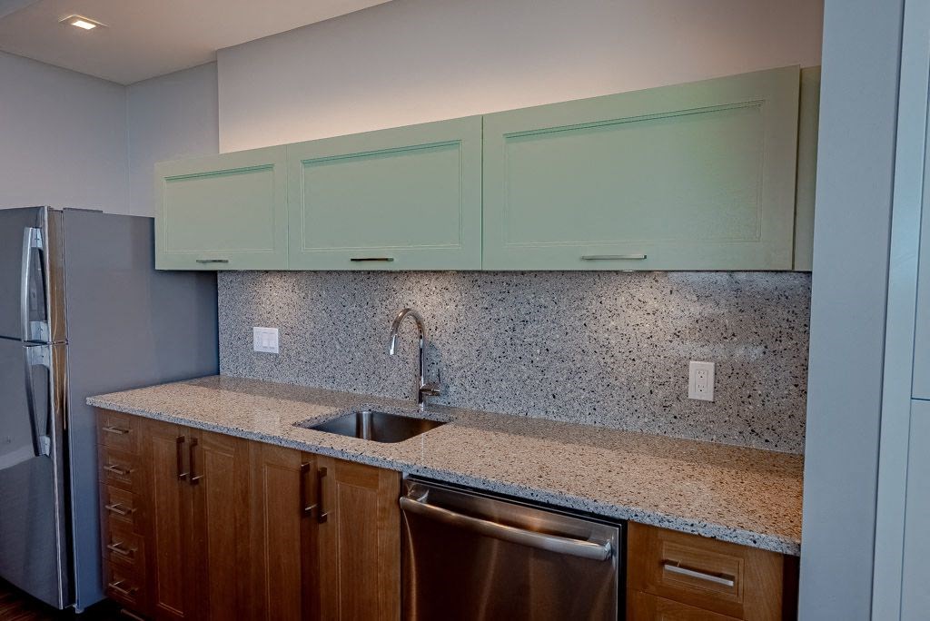a kitchen with a sink and cabinets and a refrigerator