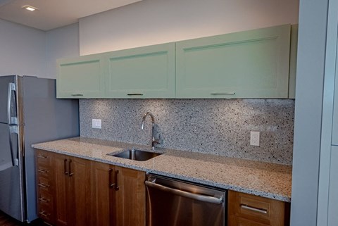 a kitchen with a sink and cabinets and a refrigerator