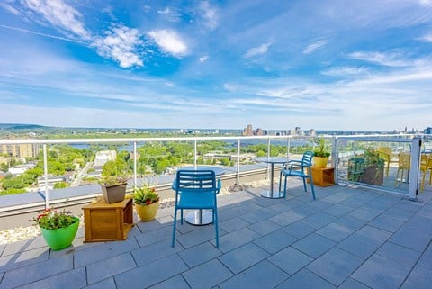 a balcony with blue chairs and a view of the city