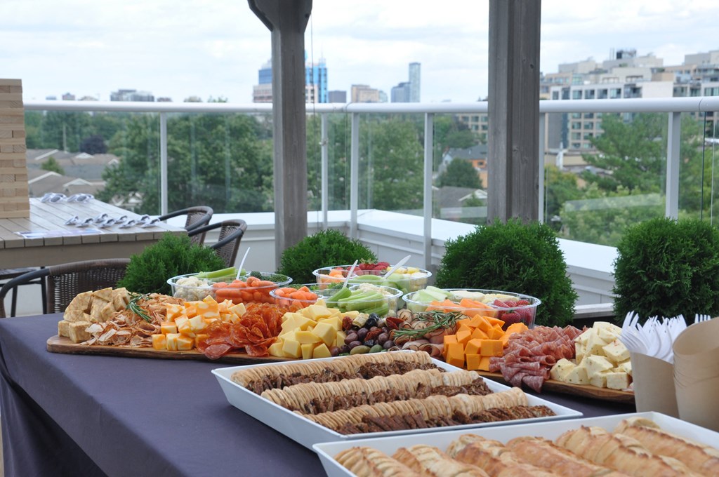 a buffet of food on a table with a city in the background