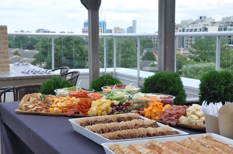 a buffet of food on a table with a city in the background