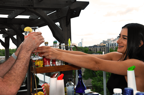 a man and a woman pouring drinks from a bar