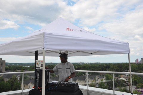 a man standing under a white tent on top of a roof