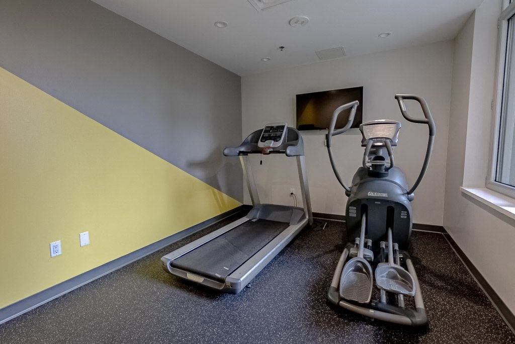 a gym with a treadmill and a tv