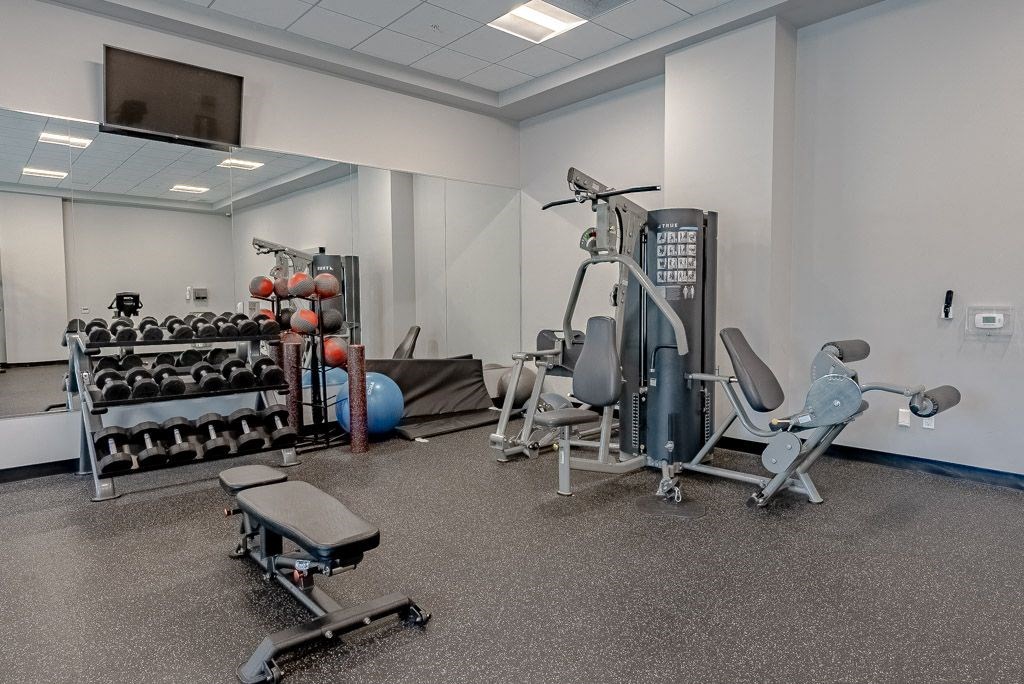 a gym with weights and cardio equipment in a building