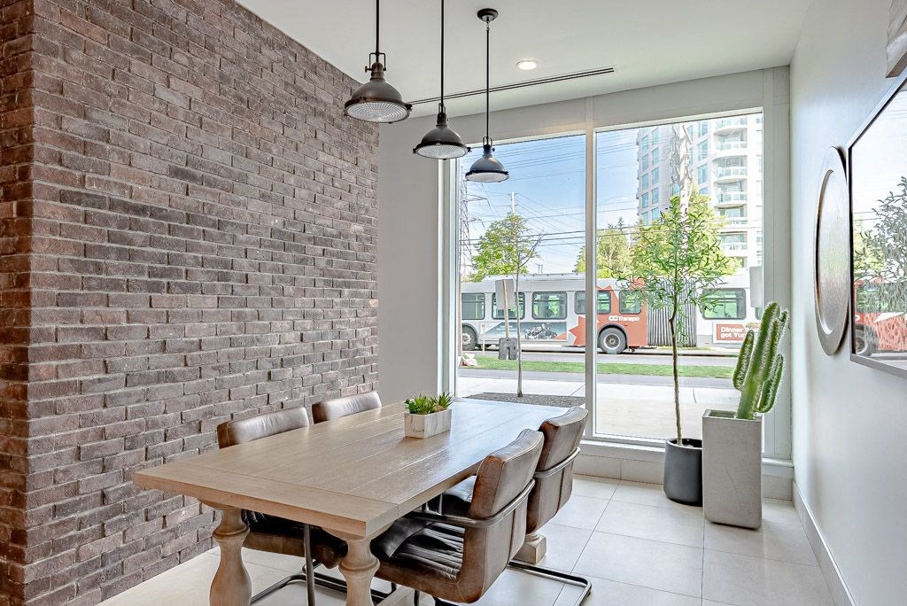 a dining room with a table and chairs and a brick wall