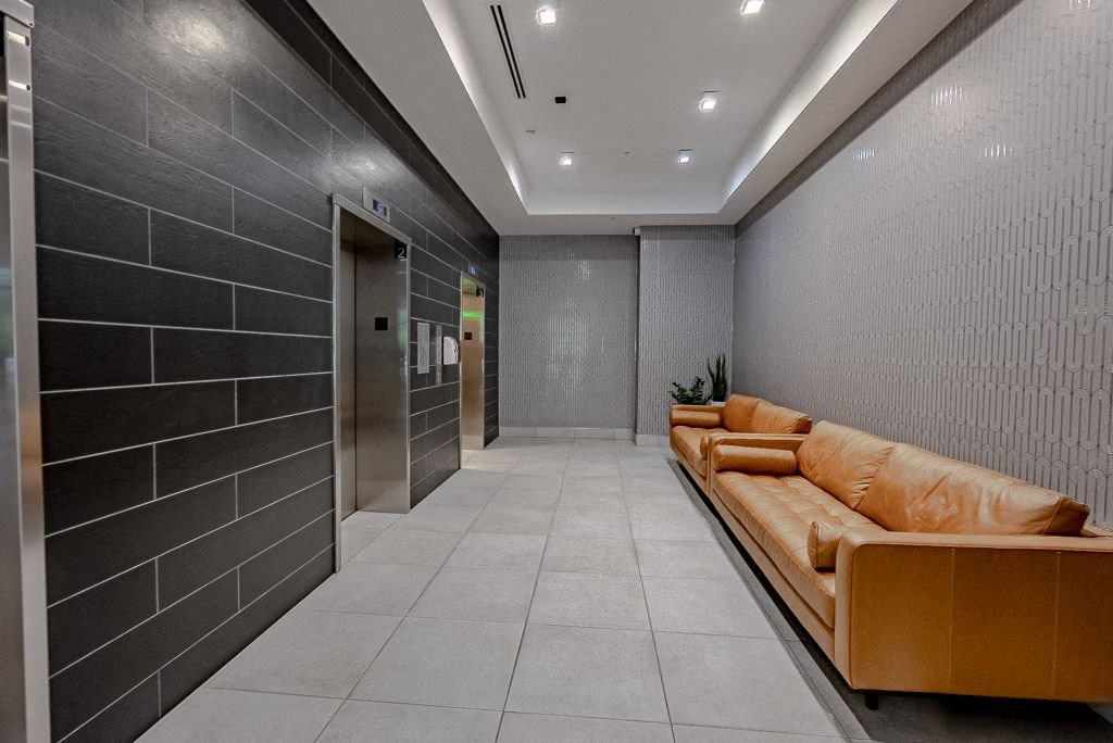 a lobby with a couch and a hallway with elevators