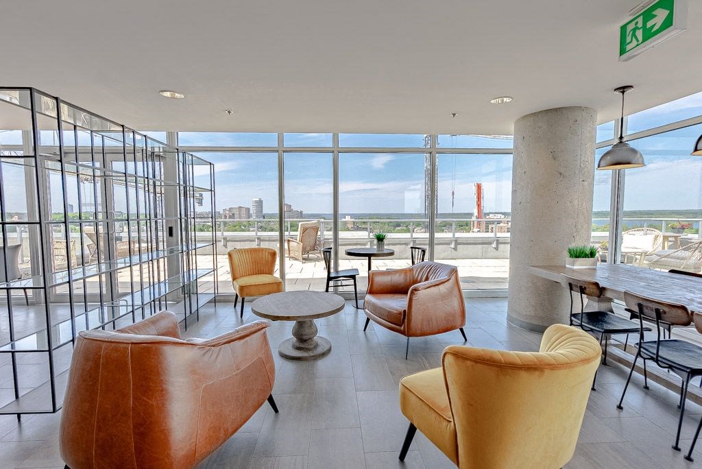 a lounge area with leather chairs and a view of the city
