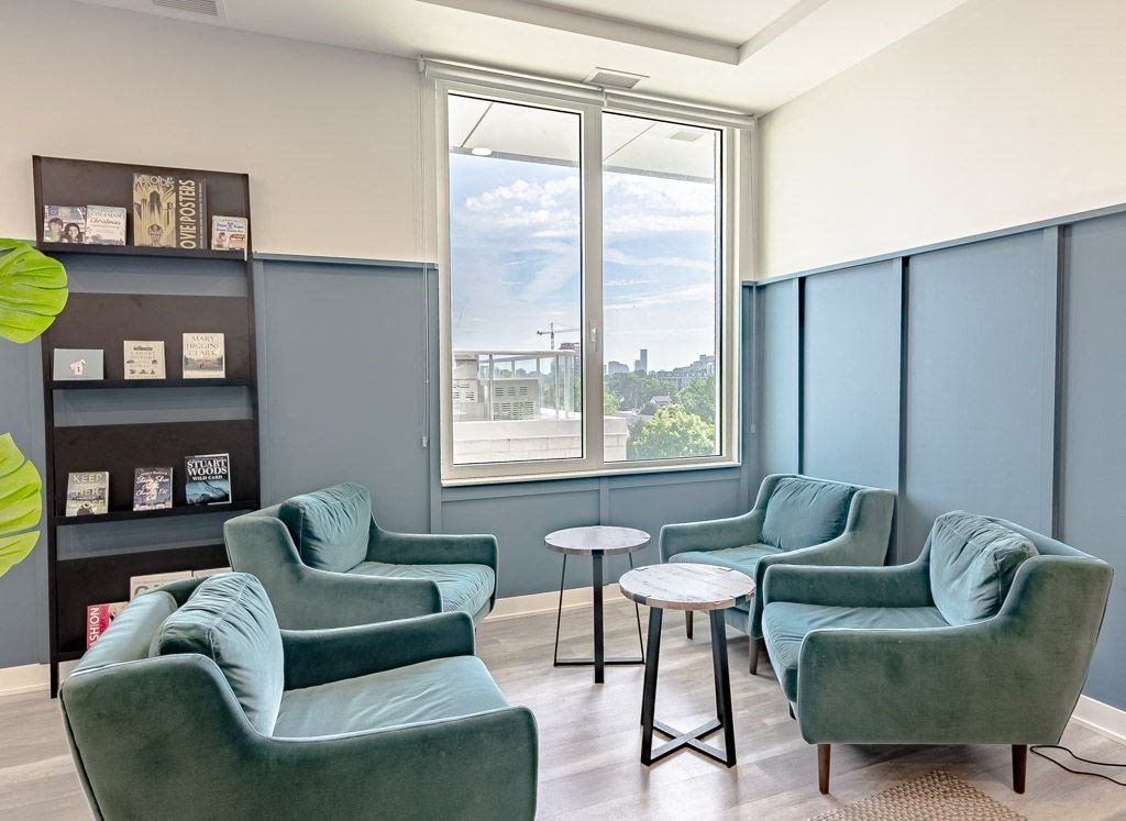 a living room with blue chairs and a window