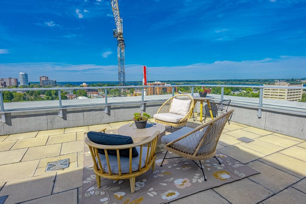 a rooftop terrace with a table and chairs and a view of the city