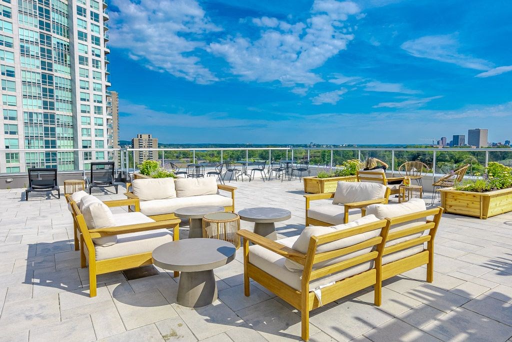 a rooftop patio with chairs and tables overlooking the city