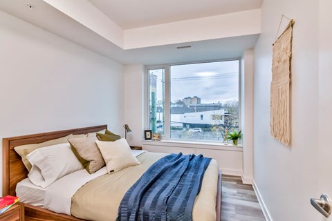 a bedroom with a bed and a large window